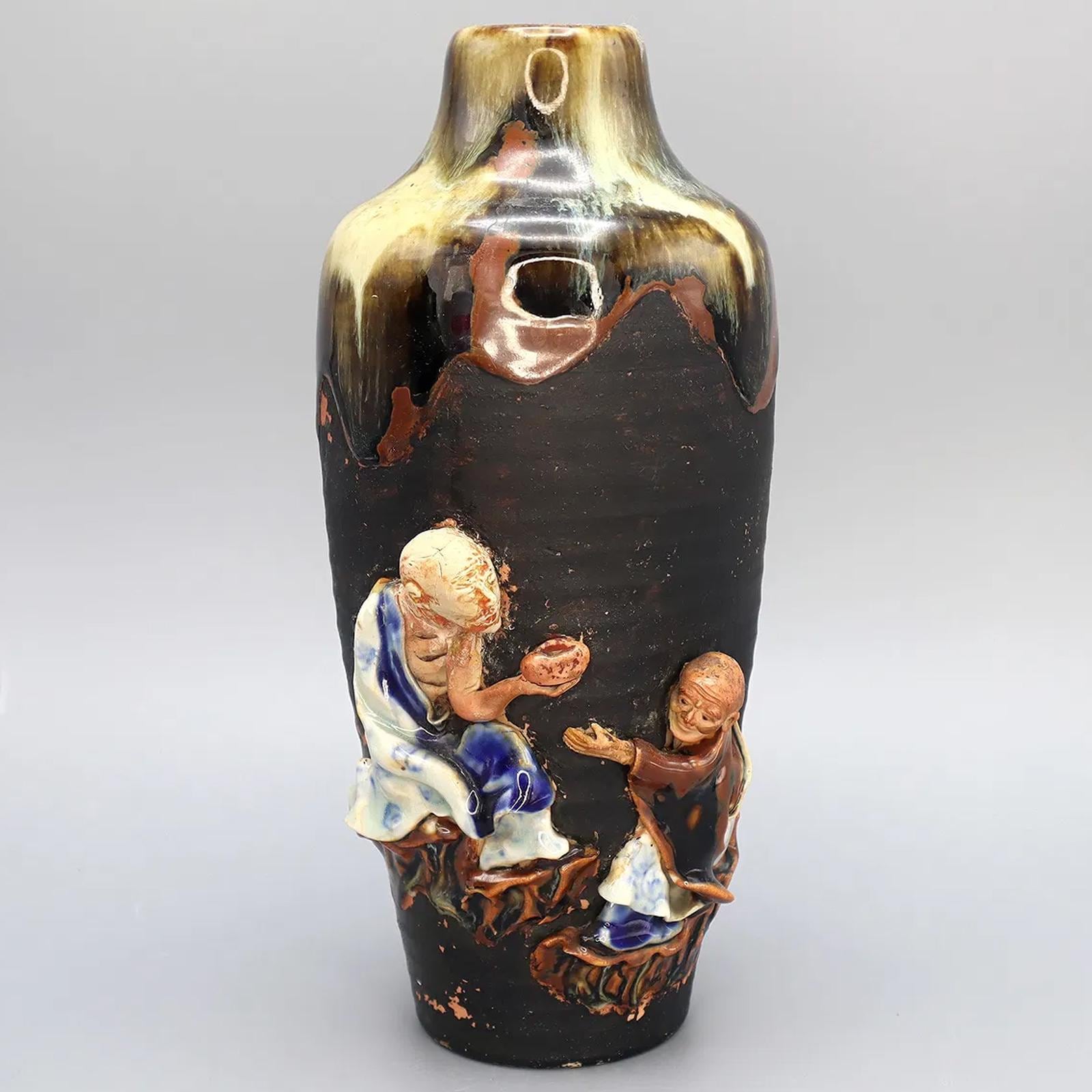 Antique Early 20th Century Japanese Sumida Gawa Drip Pottery Vase. A Tall Dark Brown Vase With Two Applied Figurines Of Old Men, Taisho Era