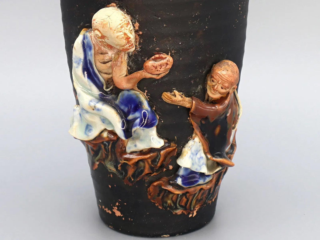 Antique Early 20th Century Japanese Sumida Gawa Drip Pottery Vase. A Tall Dark Brown Vase With Two Applied Figurines Of Old Men, Taisho Era